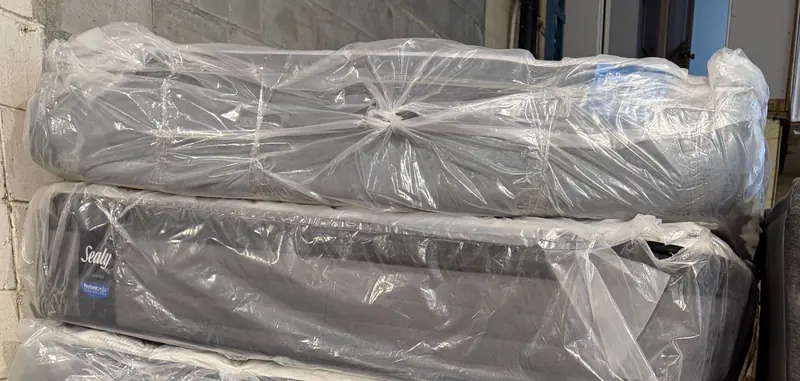 Sealy mattresses stacked in plastic covers